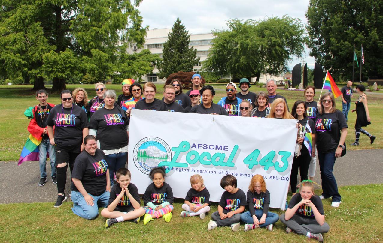 WFSE Local 443 members and their families hold a banner and pose during the Olympia Pride parade.